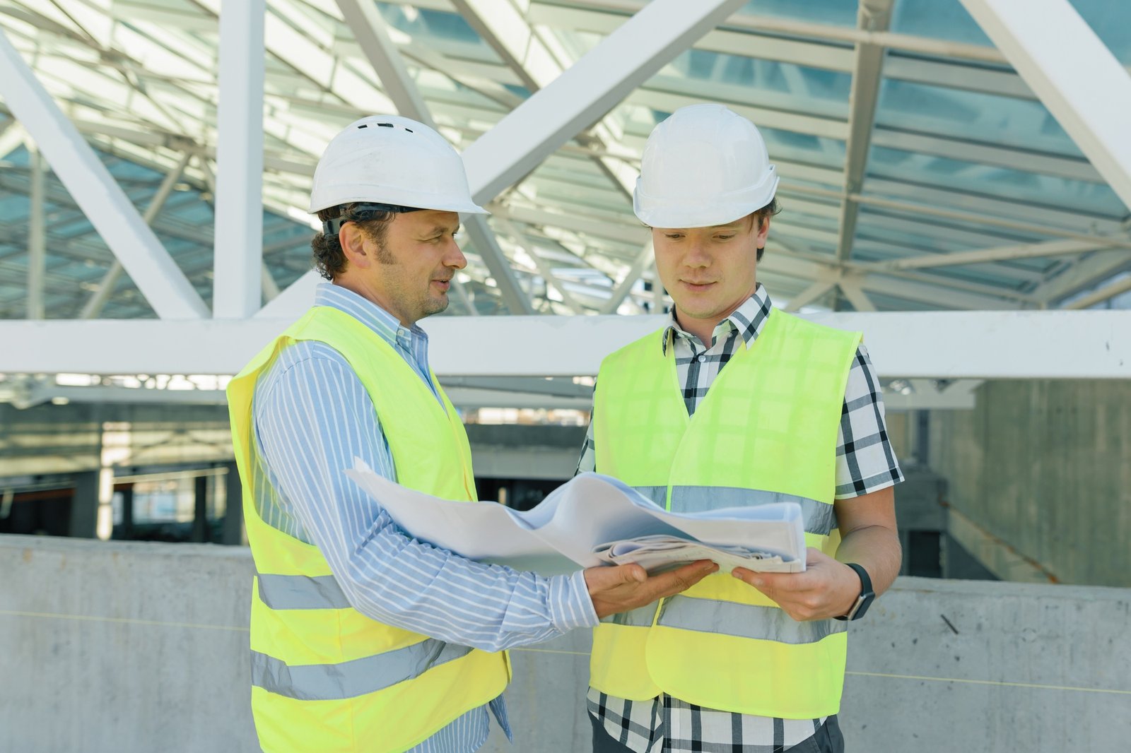 Male builders on the roof of construction site.